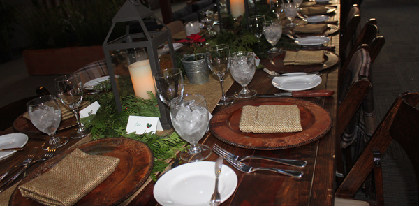Beautiful dinnerware and floral arrangements decorate a table.